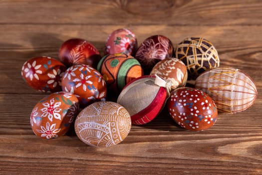 Easter composition of several Easter eggs with brown tones arranged on old brown boards. Blank bowl for adding inscriptions.