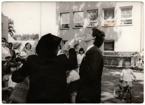 THE CZECHOSLOVAK SOCIALIST REPUBLIC - CIRCA 1970s: Retro photo shows young man drinks spirit before rural wedding ceremony. Black and white vintage photography.