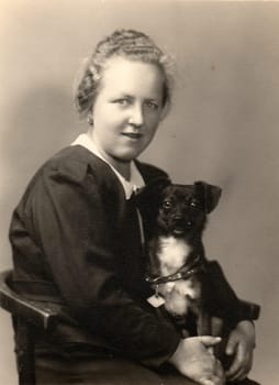 THE CZECHOSLOVAK SOCIALIST REPUBLIC - CIRCA 1950s: Retro photo shows woman with dog, studio portrait. Black and white vintage photography.