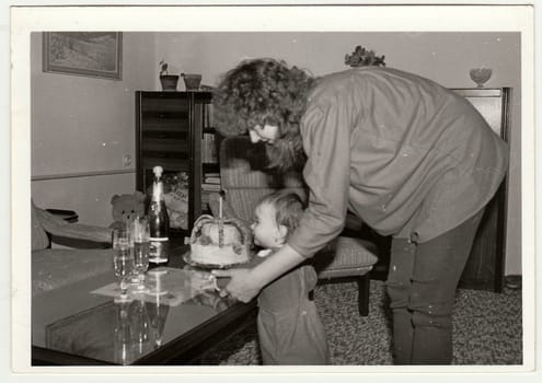 THE CZECHOSLOVAK SOCIALIST REPUBLIC - CIRCA 1970s: Retro photo shows mother and small girl during her first birthday. Black and white vintage photography.