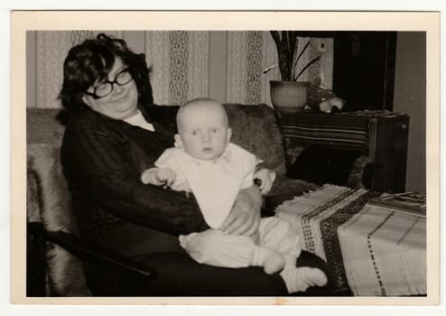 THE CZECHOSLOVAK SOCIALIST REPUBLIC - CIRCA 1970s: Retro photo shows grandmother cradles a small baby. Black and white vintage photography.