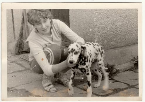 THE CZECHOSLOVAK SOCIALIST REPUBLIC - CIRCA 1970s: Retro photo shows girl with dog. Black and white vintage photography.
