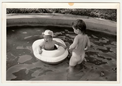 THE CZECHOSLOVAK SOCIALIST REPUBLIC - CIRCA 1970s: Retro photo shows children in the outdoor pool during summer time. Black and white vintage photography.