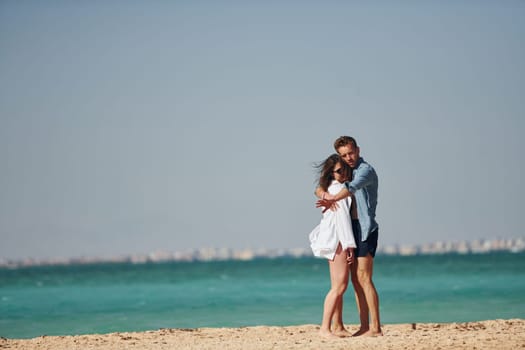 Young european couple have vacation together on the sea at sunny daytime.