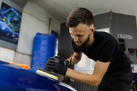 Abrasive paste car polishing with orbital polisher for remove scratches. Worker of detailing auto service making final polishing for car