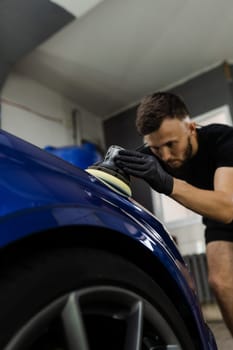 Hard wax car polishing with orbital polisher for remove scratches close-up. Working process in detailing auto service