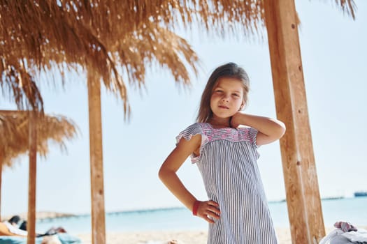 Little girl have vacation on the sea at sunny daytime. Conception of travel.