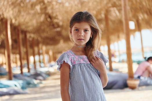 Little girl have vacation on the sea at sunny daytime. Conception of travel.