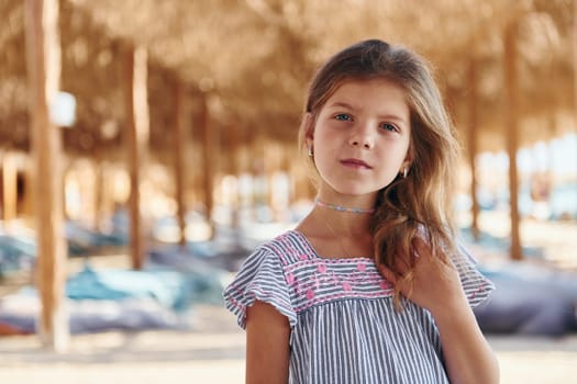 Little girl have vacation on the sea at sunny daytime. Conception of travel.