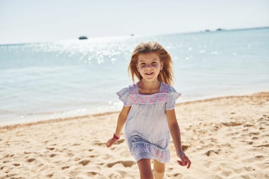 Little girl have vacation on the sea at sunny daytime. Conception of travel.