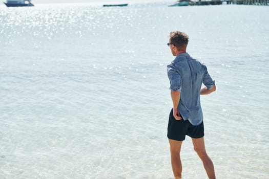 Clear water. Young european man have vacation and enjoying free time on the beach of sea.