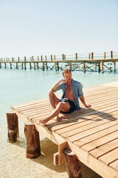 Clear water. Young european man have vacation and enjoying free time on the beach of sea.