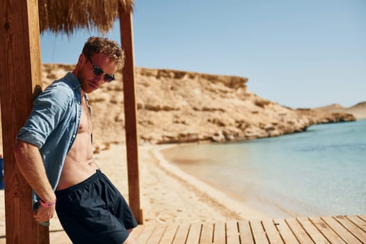 Clear water. Young european man have vacation and enjoying free time on the beach of sea.
