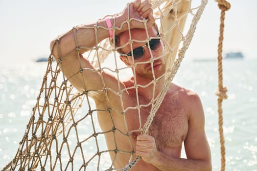 Warm weather. Young european man have vacation and enjoying free time on the beach of sea.