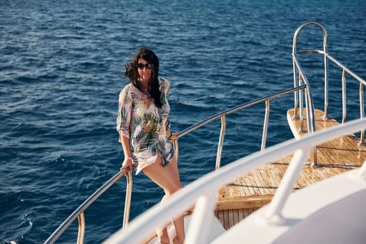 Mature woman standing on the yacht and enjoying her vacation on the sea.