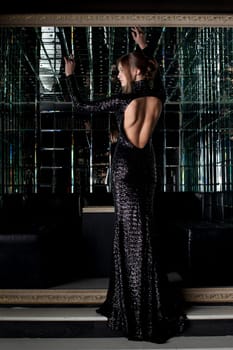 Full length portrait of beautiful young woman in long black dress