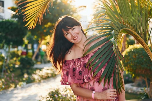 Happy mature woman is outdoors enjoying her vacation at sunny daytime.