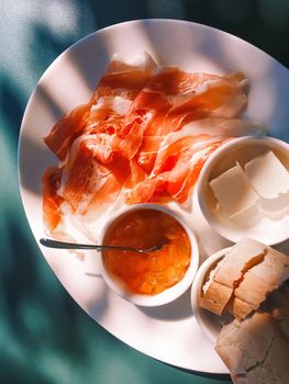 Breakfast outdoors in summer, ham, jam, butter and ham.