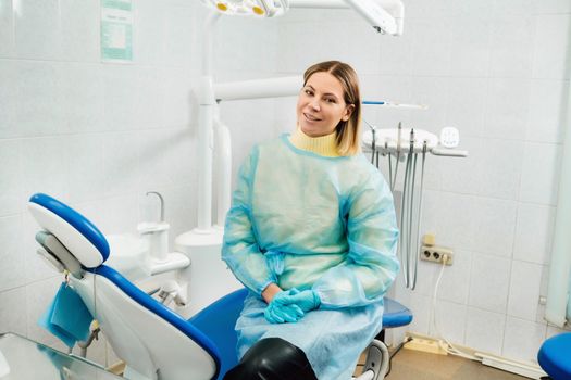 a female dentist sits in her dental office after work.