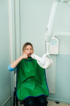 They take a picture of the girl in the X-ray dental office in the hospital.