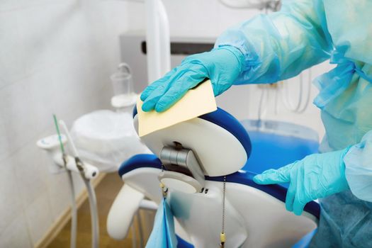 A nurse disinfects work surfaces in the dentist's office..