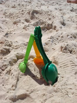 Set of color plastic children toys on sand near sea. Beach object.