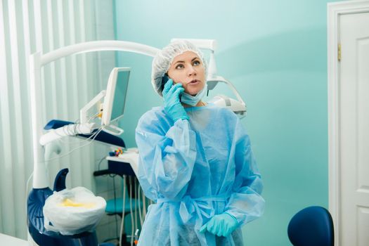 a female dentist is on the phone in her dental office.