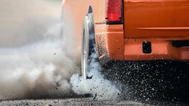 Drag racing car burns rubber off its tires in preparation for the race
