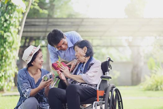 Son and daughter in law gift elderly mother in backyard