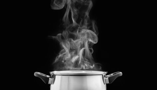 steam over cooking pot in kitchen on dark background