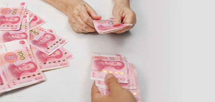 Chinese Senior woman counting money for payment