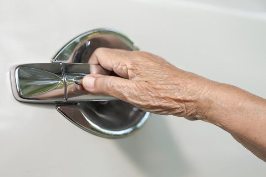 elderly woman hand opening car door