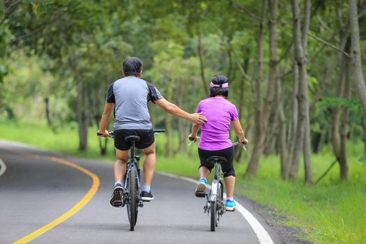 Middle aged couple relaxing exercise with bicycle in park