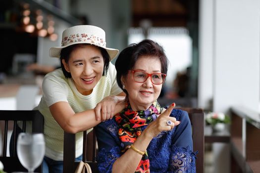 Senior asian woman with daughter relaxing on vacation together.