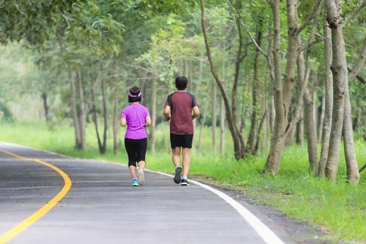 Asian middle aged couple jogging and running in park