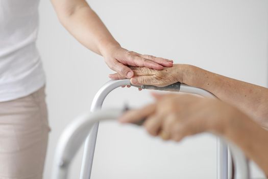 Elderly asian woman using a walker at home with caregiver take care