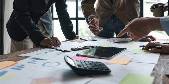 Business People Meeting using laptop computer, calculator, stock market chart paper for analysis planning to improve quality next month. Conference Discussion Corporate Concept.