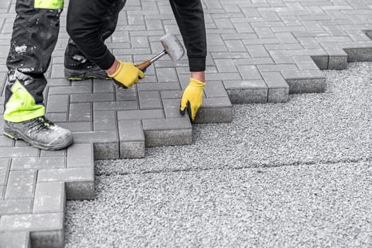 rubber hammer for adjusting the lock paving on the sidewalk. High quality photo
