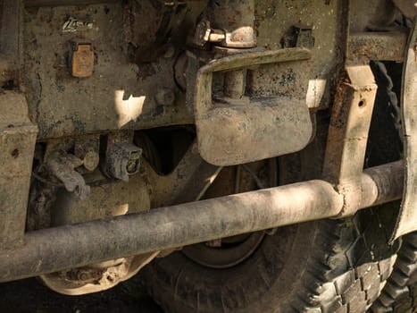 Closeup of old rusty and dirty truck back, large tire and tow mechanism visible.