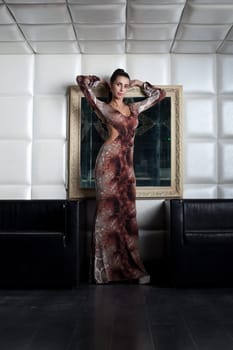 Gorgeous slim brunette posing in brown long dress