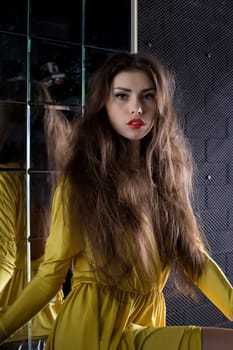 Portrait of beautiful brunette woman near mirror