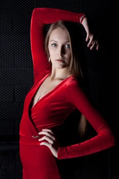 Portrait of beautiful young woman in red dress in dark
