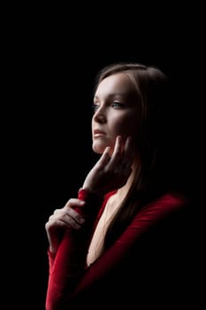 Portrait of beautiful young woman in red dress posing in dark nightclub