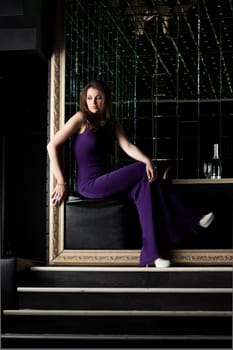 Sexy woman sitting in purple long dress, close-up