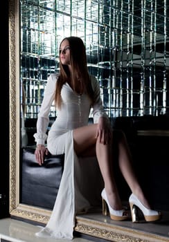 Beautiful girl sitting in fashionable long dress, close-up