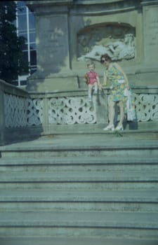 THE CZECHOSLOVAK SOCIALIST REPUBLIC - 1973: Retro photo shows mother and son with toy outdoors.