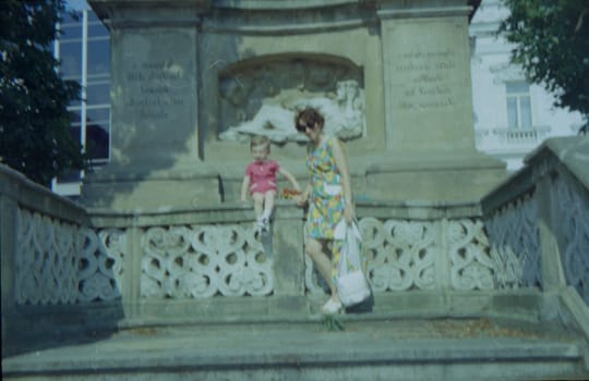 THE CZECHOSLOVAK SOCIALIST REPUBLIC - 1973: Retro photo shows mother and son with toy outdoors.