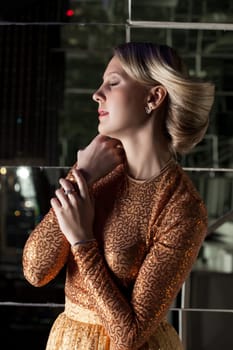 Portrait of pretty blonde in golden dress, close-up