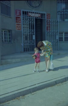 THE CZECHOSLOVAK SOCIALIST REPUBLIC - 1973: Retro photo shows mother and son with toy outdoors.