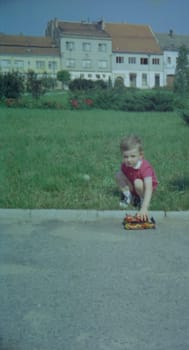 THE CZECHOSLOVAK SOCIALIST REPUBLIC - 1973: Retro photo shows boy with toy outdoors.